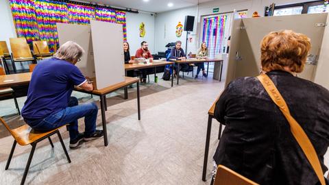Wähler geben in einem Wahllokal in Duisburg ihre Stimme ab.
      