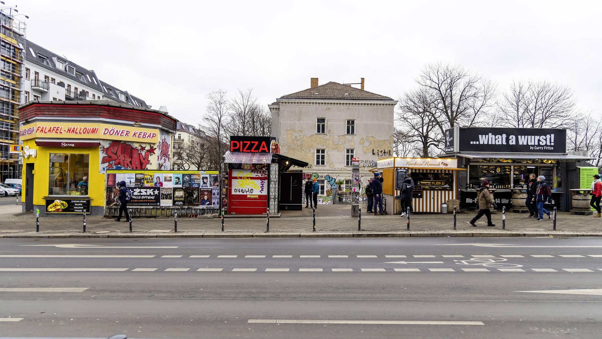 Eine Döner-, Pizza- und Currywurstbude nebeneinander.