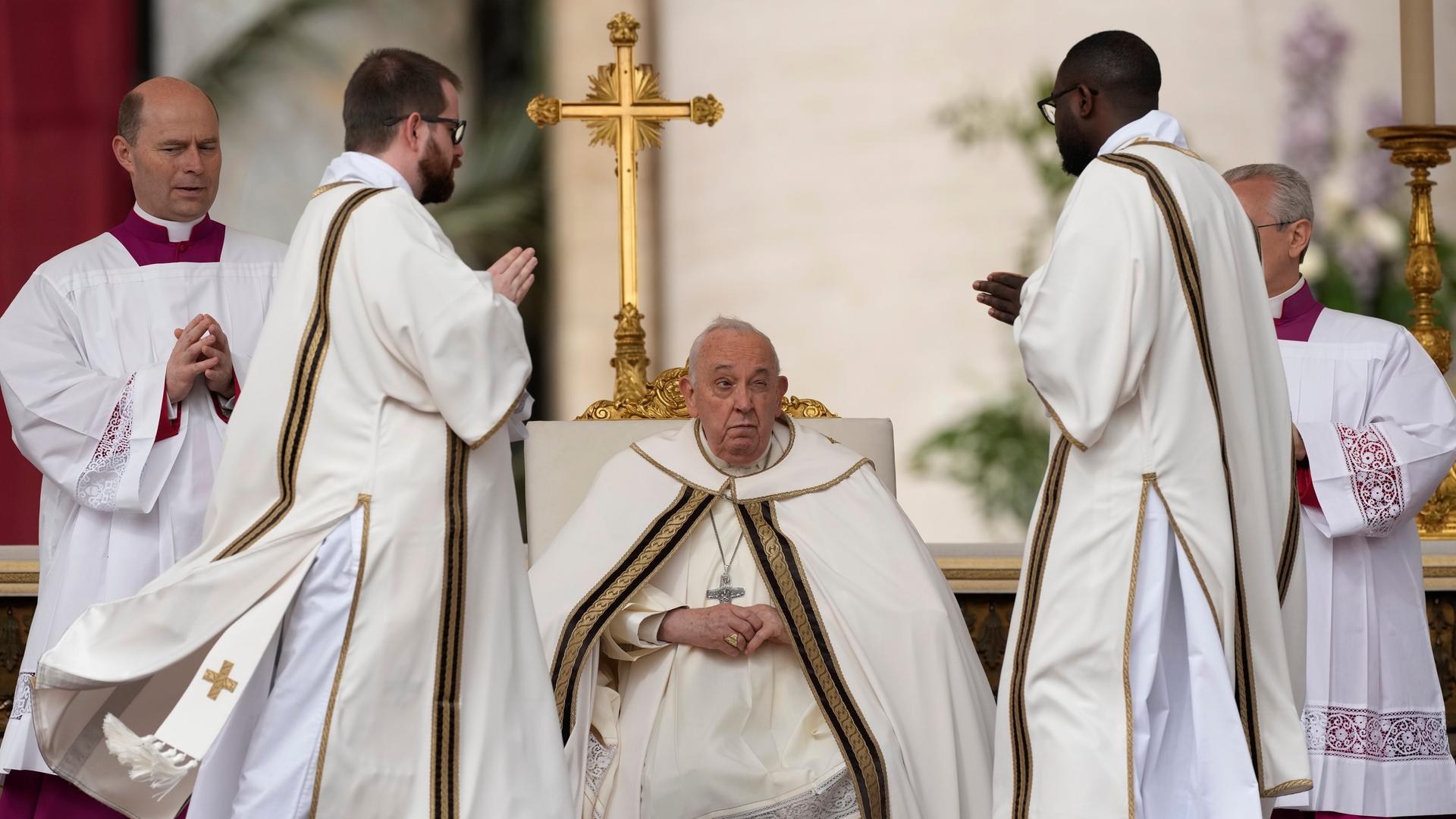 Papst Franziskus in einem weißen Gewand auf dem Petersplatz im Vatikan. Er sitzt auf einem Stuhl und zelebriert die Ostermesse.