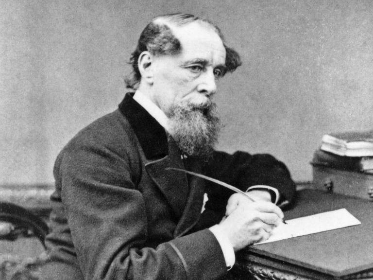 Schwarzweißporträt von Charles Dickens in nachdenklicher Pose am Schreibtisch