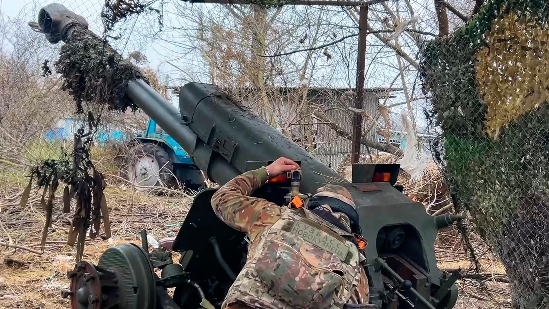 Auf diesem Foto aus einem vom Pressedienst des russischen Verteidigungsministeriums veröffentlichten Video zielt ein russischer Soldat mit einer Haubitze auf ukrainische Stellungen im Grenzgebiet der Region Kursk. 