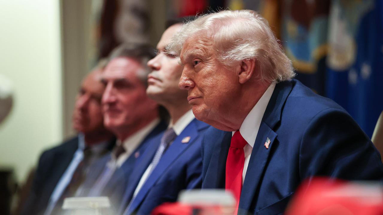 US-Präsident Trump sitzt mit einigen Ministern an einem Konferenztisch und blickt in die Runde. 