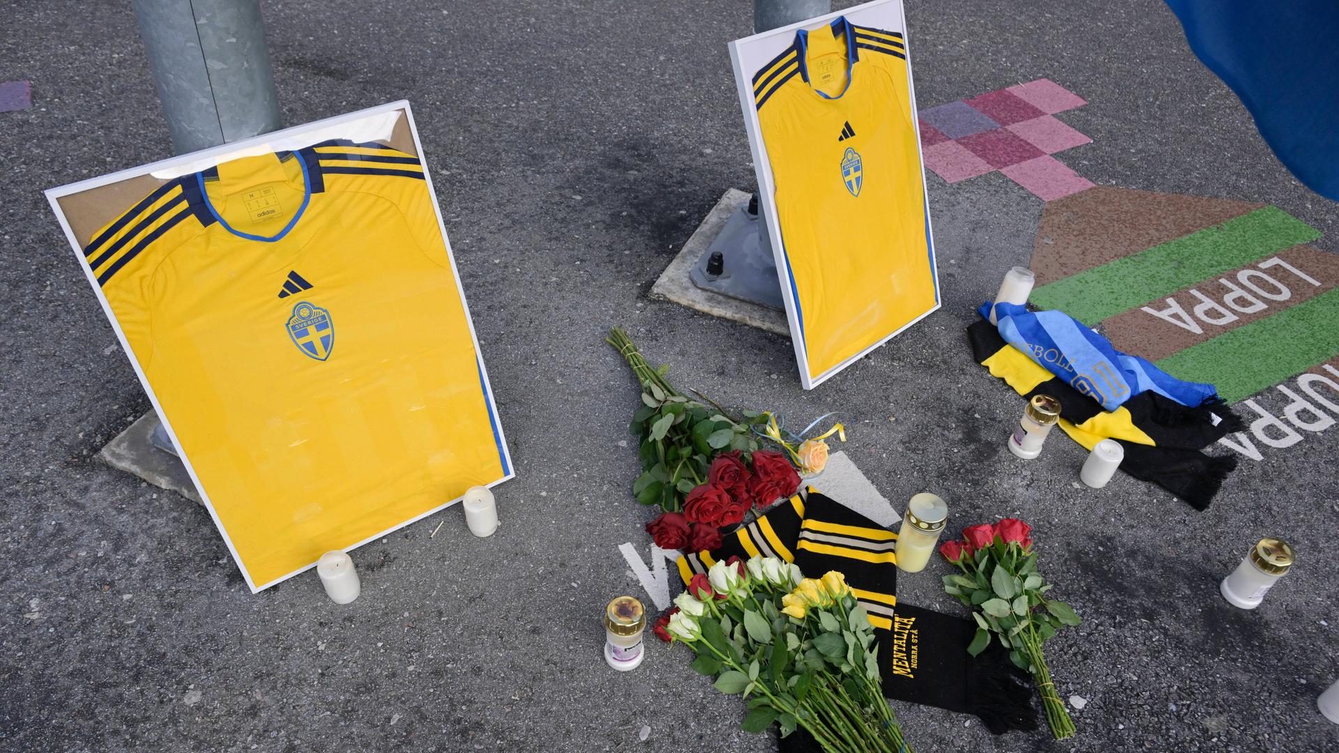 Blumen, Kerzen und zwei gerahmte schwedische Fußballtrikots stehen vor der Friends Arena in Solna in Gedenken an die zwei ermordeten Fußballfans in Brüssel. 