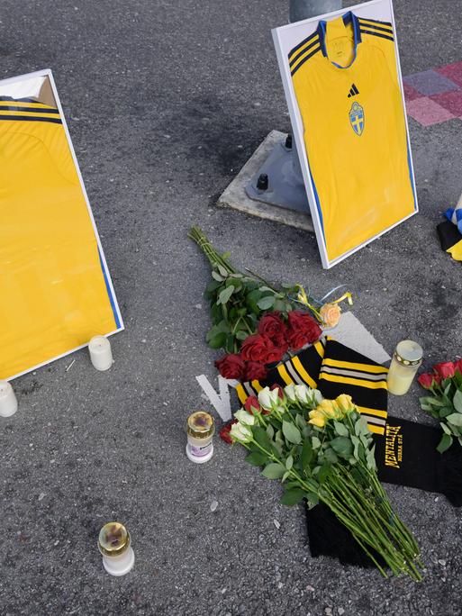 Blumen, Kerzen und zwei gerahmte schwedische Fußballtrikots stehen vor der Friends Arena in Solna in Gedenken an die zwei ermordeten Fußballfans in Brüssel. 