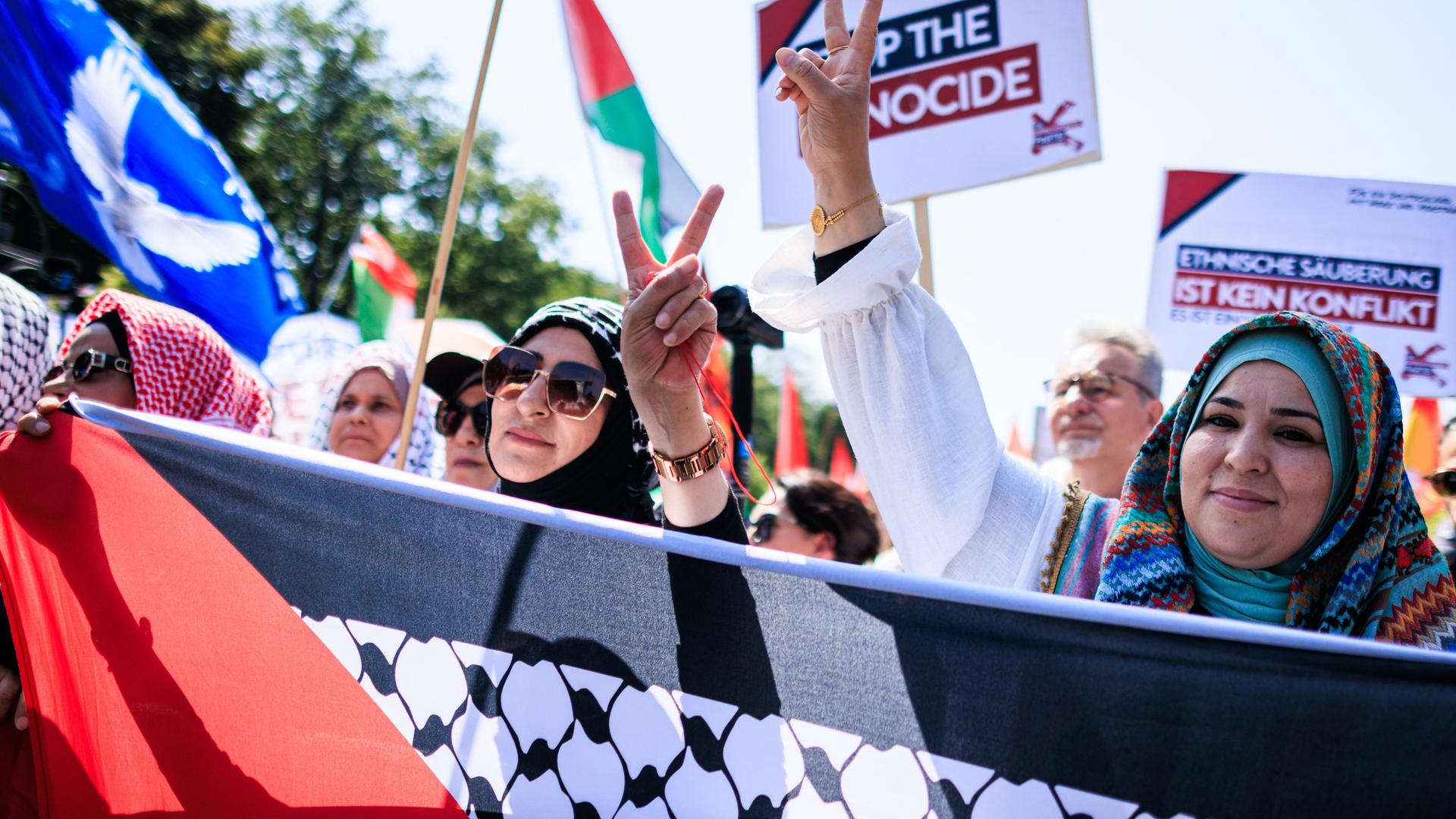 Teilnehmer der Kundgebung demonstrieren in Berlin mit palästinensischen Fahnen und Bannern für die Solidarität mit den Palästinensischen Gebieten Teilnehmer der Kundgebung demonstrieren in Berlin mit palästinensischen Fahnen und Bannern für die Solidarität mit den Palästinensischen Gebieten
