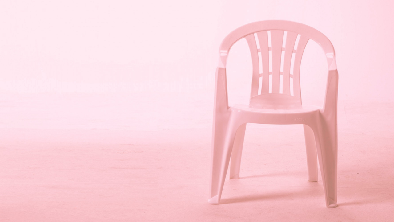 Ein Plastikstuhl mit rosa Hintergrund. 