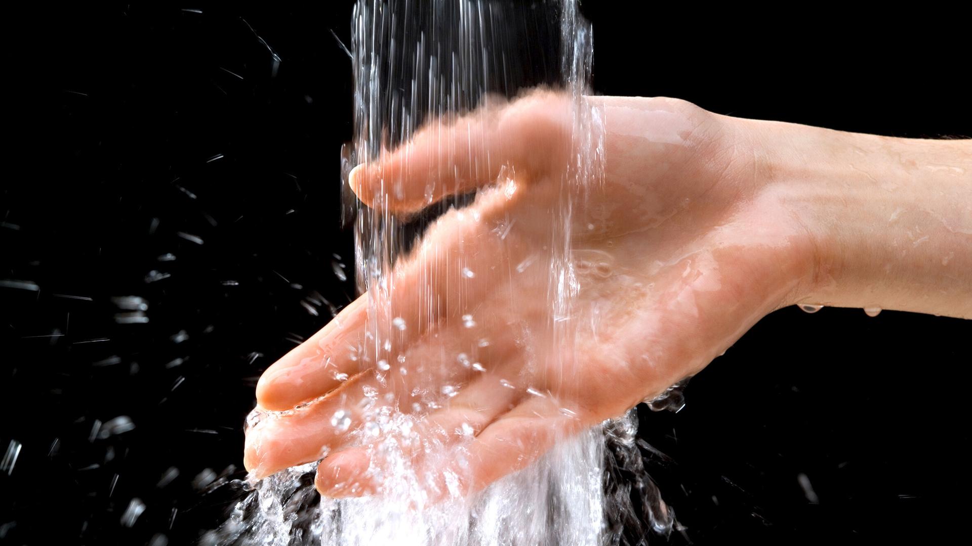 Hände unter einem Wasser-Strahl Hände unter einem Wasser-Strahl