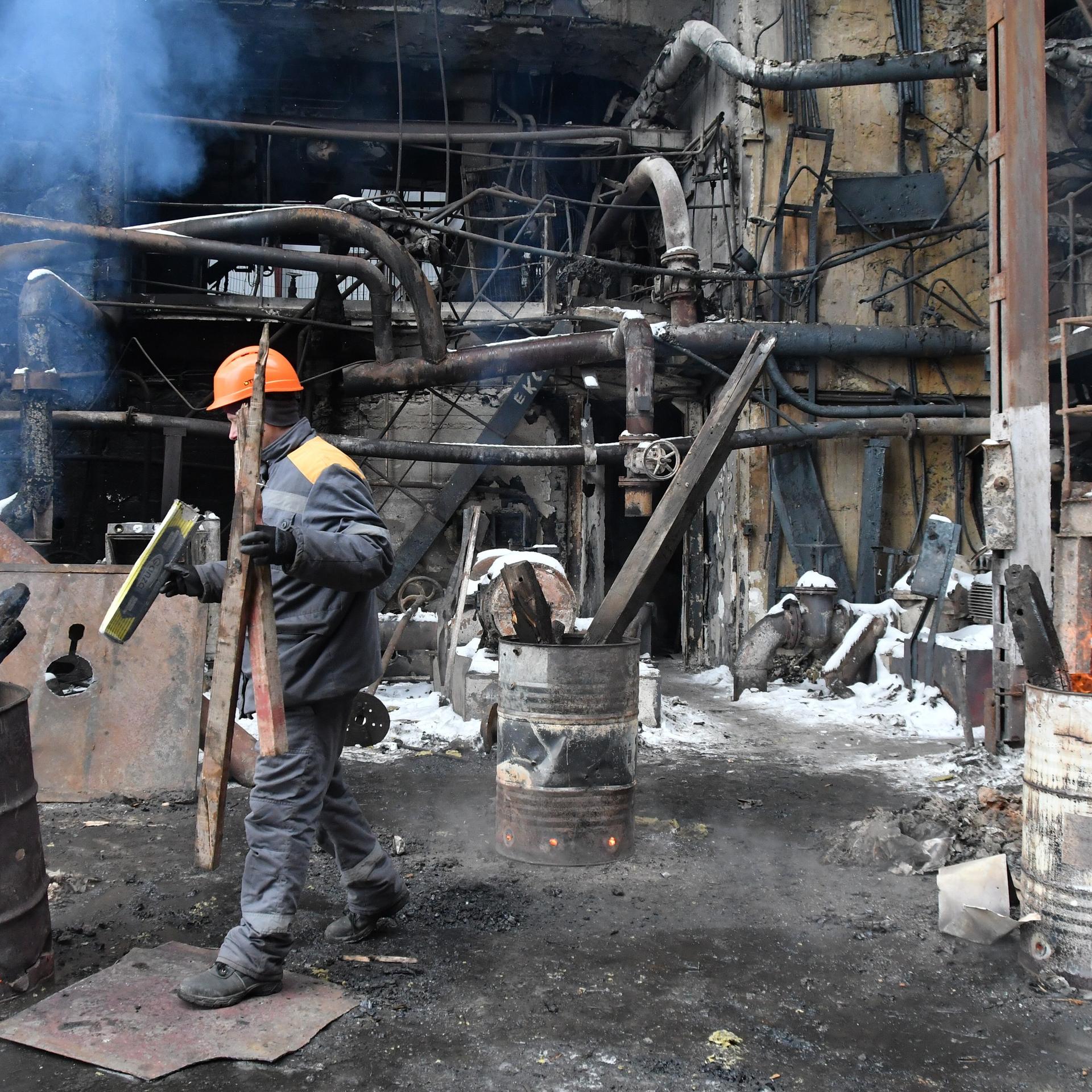 Arbeiter reparieren ein Kraftwerk, das durch einen russischen Angriff beschädigt wurde. 