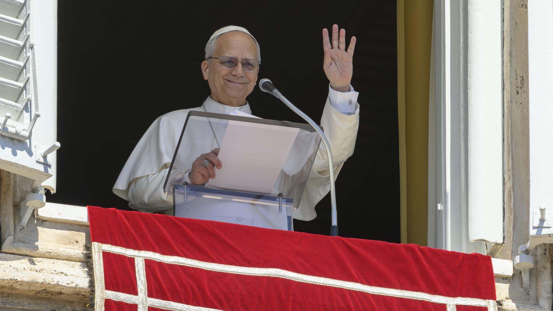 Papst Leo XIV. winkt während des Mittagsgebetes aus dem Fenster zu den Gläubigen