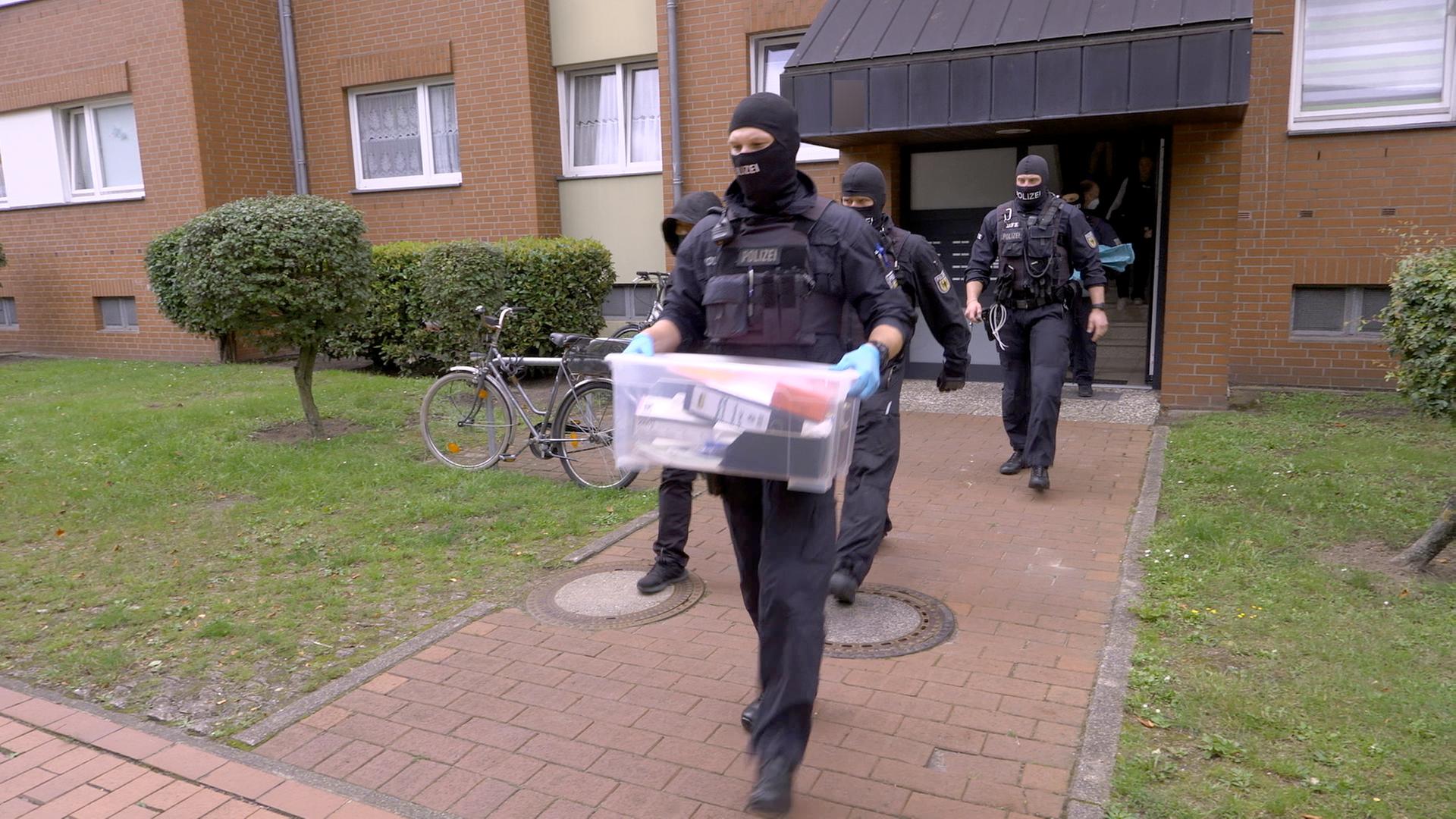Polizeibeamte stellen bei einer Großrazzia im Stadtteil Groß-Buchholz in Hannover Beweismittel sicher.
