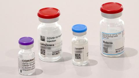 Behälter der Impfstoffe von Biontech, Astrazeneca, Johnson & Johnson und Moderna stehen auf einem Tisch