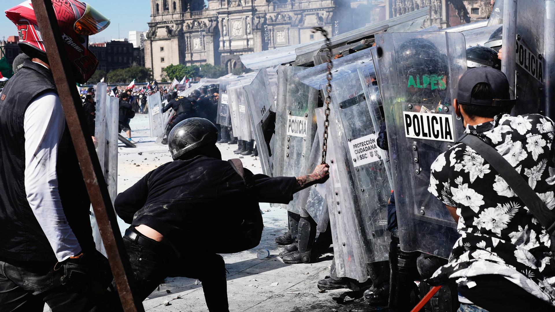 Demonstranten stürmen gegen einen Wall von Polizisten mit Schilden. Demonstranten stürmen gegen einen Wall von Polizisten mit Schilden.