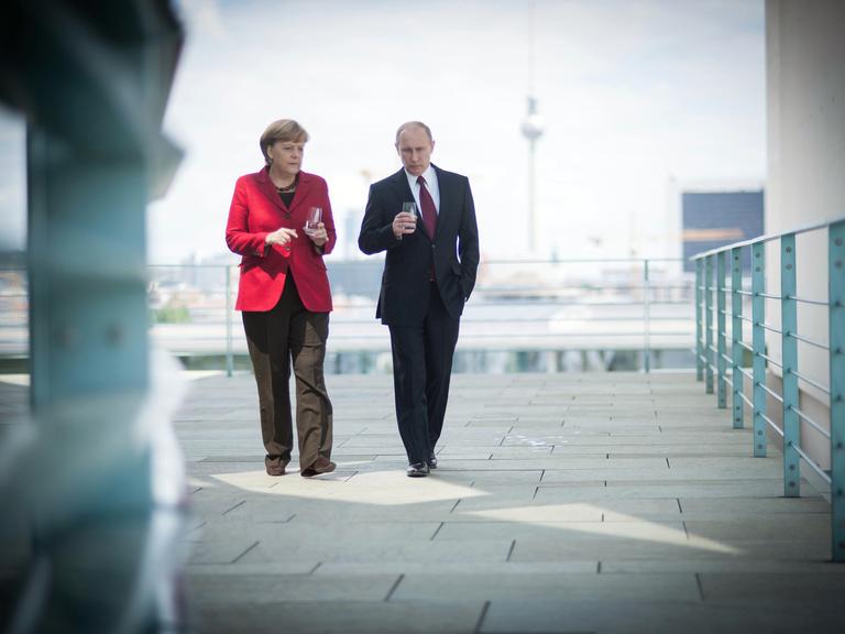 Angela Merkel geht links neben Wladimir Putin. Im Hintergrund der Berliner Fernsehturm.