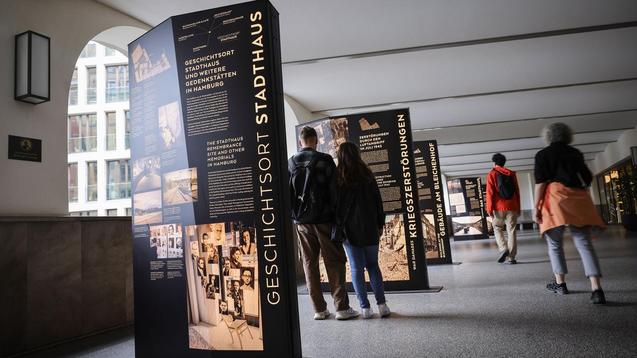 Im Hamburger Geschichtsort Stadthaus sollen die Fotos künftg zu sehen sein. Besucherinnen und Besucher stehen an Texttafeln in einem öffentlichen Durchgang.
      