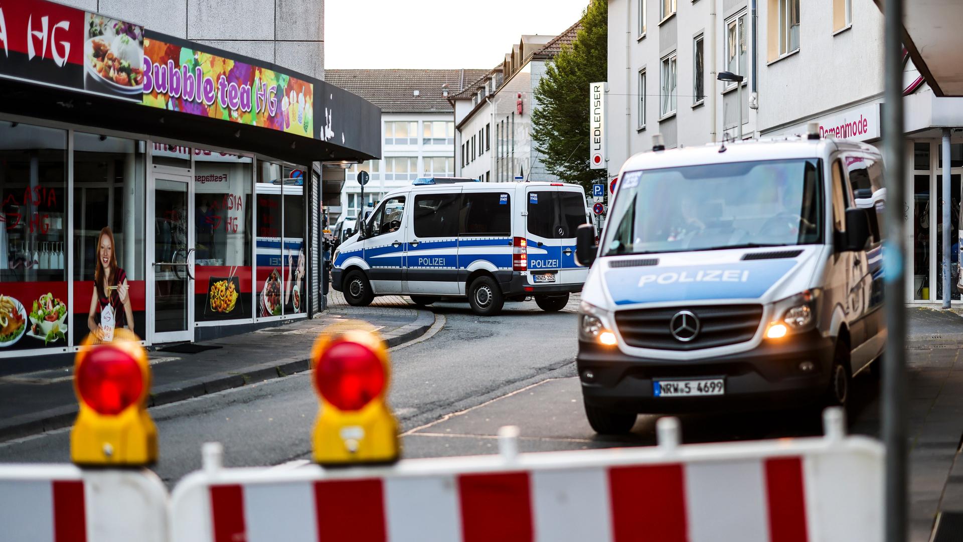 Polizeiwagen stehen am frühen Morgen an einer Absperrung in Solingen.