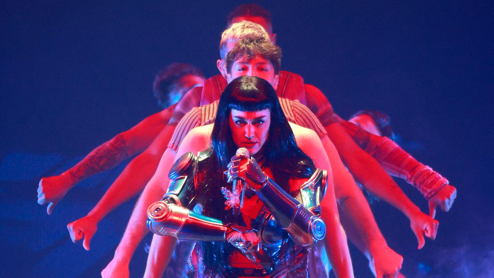 Katy Perry in einer Art Rüstung bei einem Konzert im August 2025, dahinter performen Tänzer