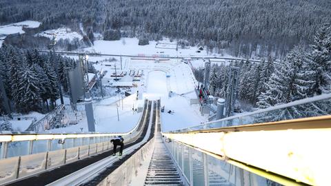 Wir sehen eine Skisprungschanze aus Sicht des Skispringers. 