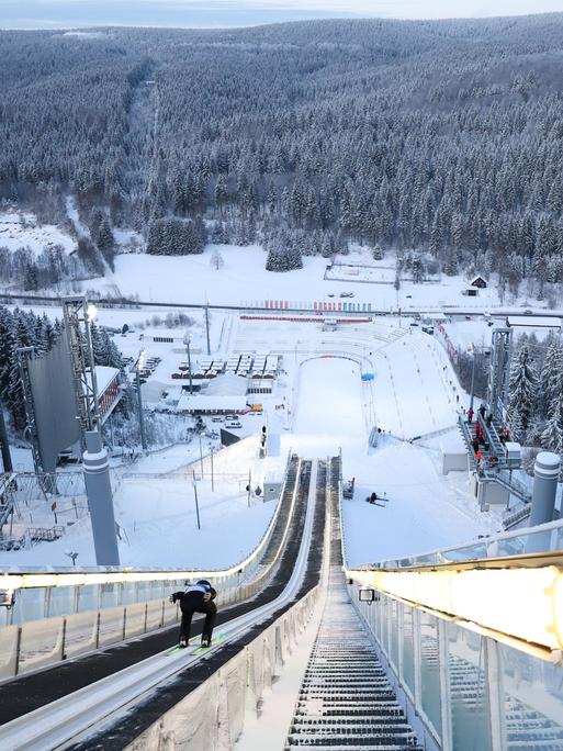 Wir sehen eine Skisprungschanze aus Sicht des Skispringers. 