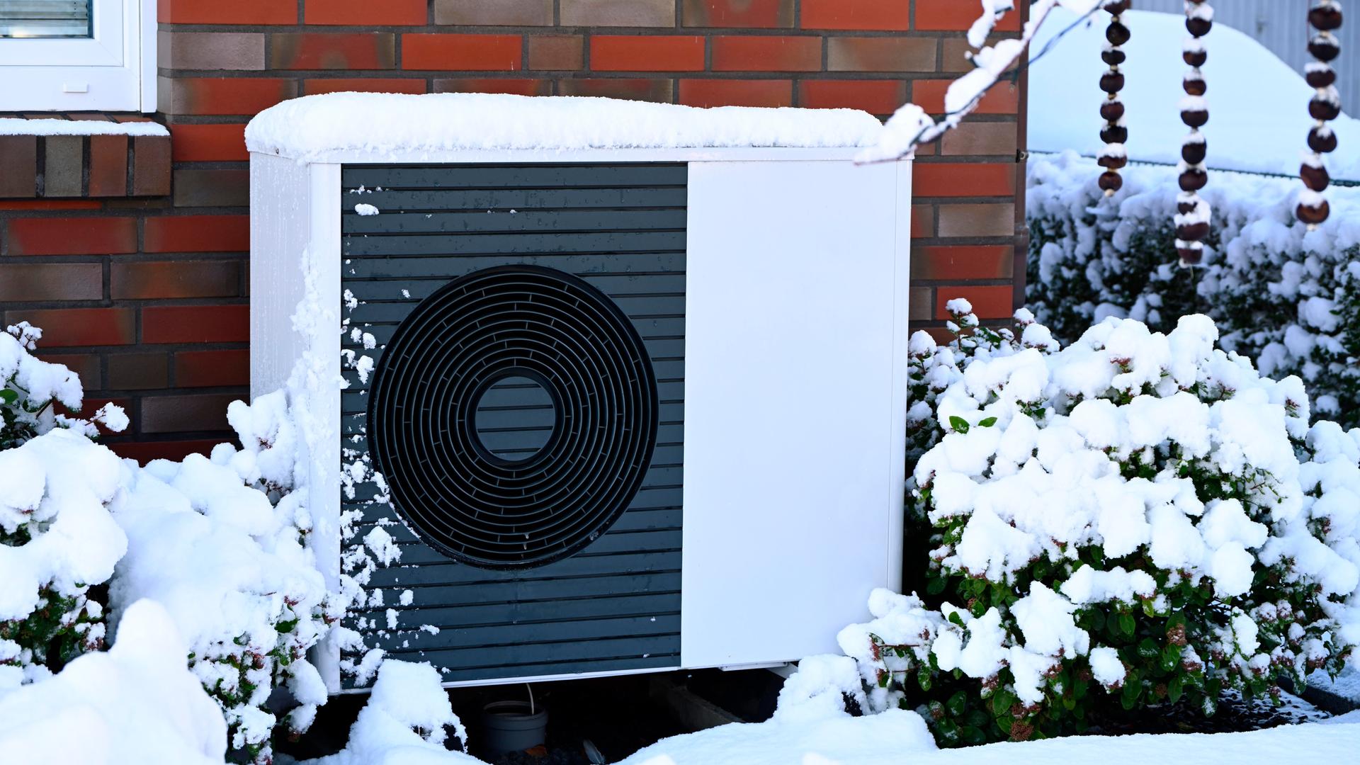 Wärme-Pumpe vor einem Wohn-Haus im Winter