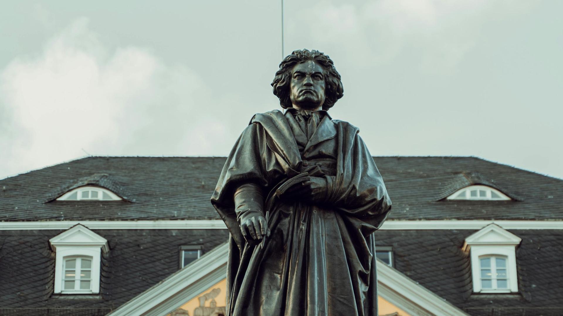 Blick auf die große Beethoven-Standfigur in Bonn, die den Komponisten mit wildem Haar und Falten werfenden Mantel zeigt. Blick auf die große Beethoven-Standfigur in Bonn, die den Komponisten mit wildem Haar und Falten werfenden Mantel zeigt.