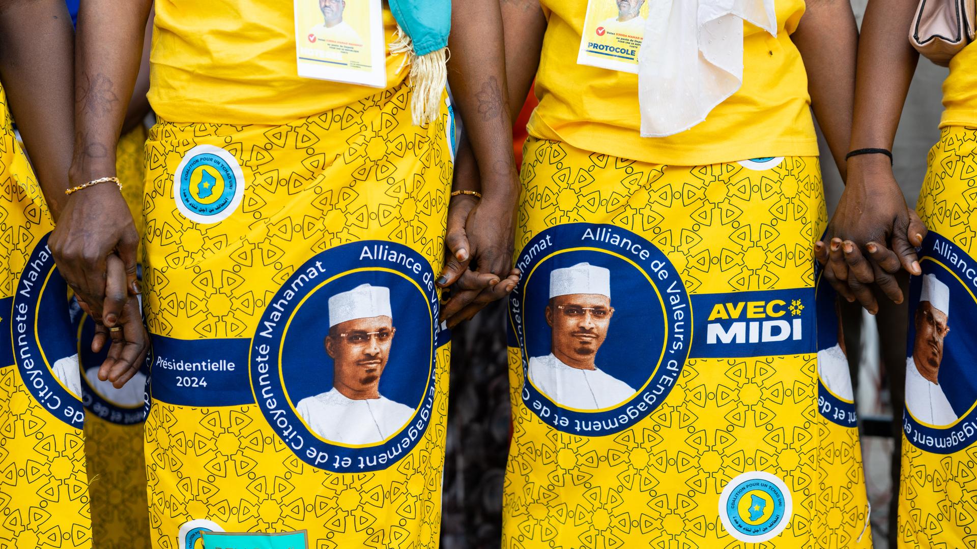 Bei einer Wahlkampfveranstaltung tragen Frauen gelbe Kleider mit dem Konterfei von Mahamat Idriss Déby auf den Röcken. Bei einer Wahlkampfveranstaltung tragen Frauen gelbe Kleider mit dem Konterfei von Mahamat Idriss Déby auf den Röcken.