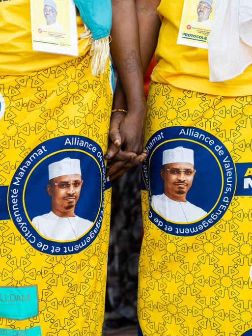 Bei einer Wahlkampfveranstaltung tragen Frauen gelbe Kleider mit dem Konterfei von Mahamat Idriss Déby auf den Röcken.