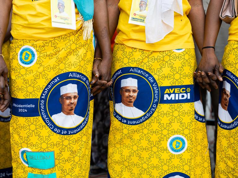 Bei einer Wahlkampfveranstaltung tragen Frauen gelbe Kleider mit dem Konterfei von Mahamat Idriss Déby auf den Röcken.