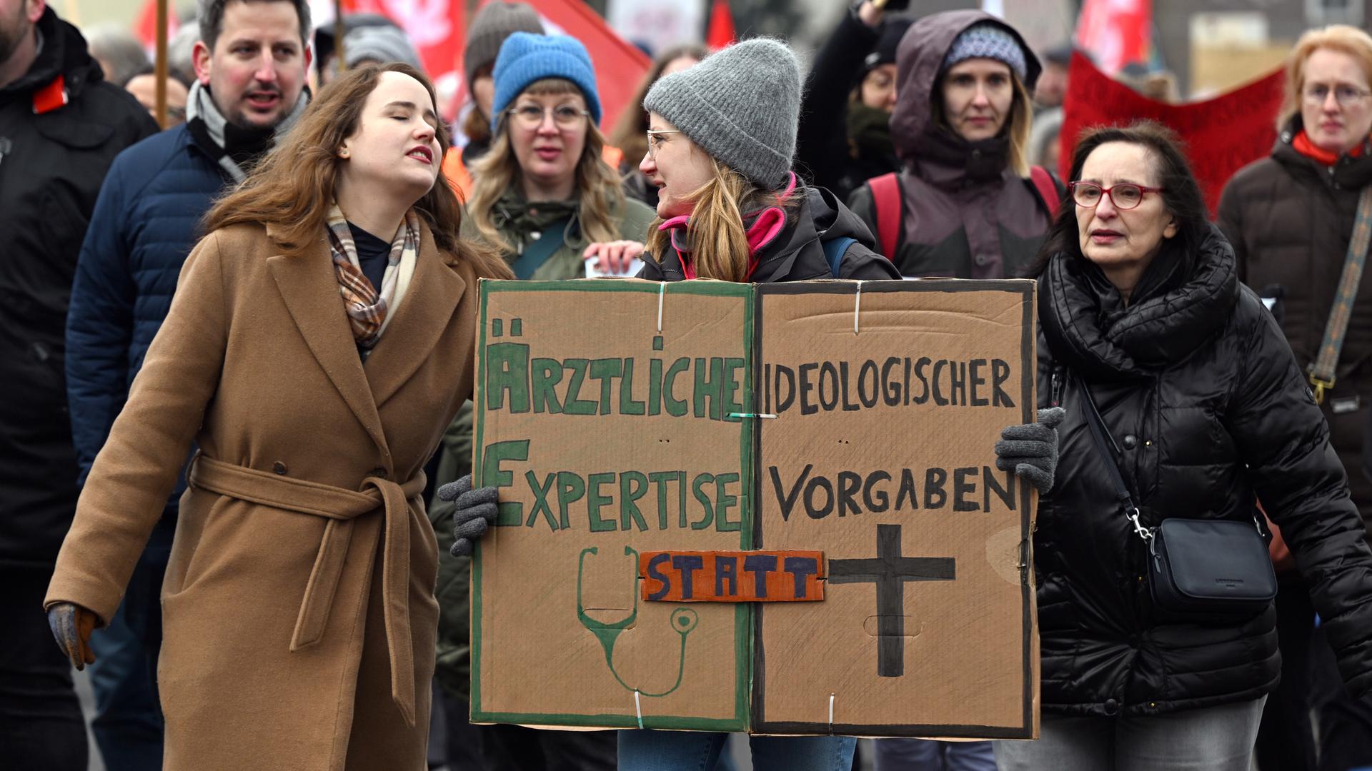 Demonstrantinnen halten Schilder in den Händen. Sie protestieren gegen das Abtreibungsverbot in einer Klinik in Lippstadt. Auf einem Schild steht: "Ärztliche Expertise statt ideologischer Vorgaben".