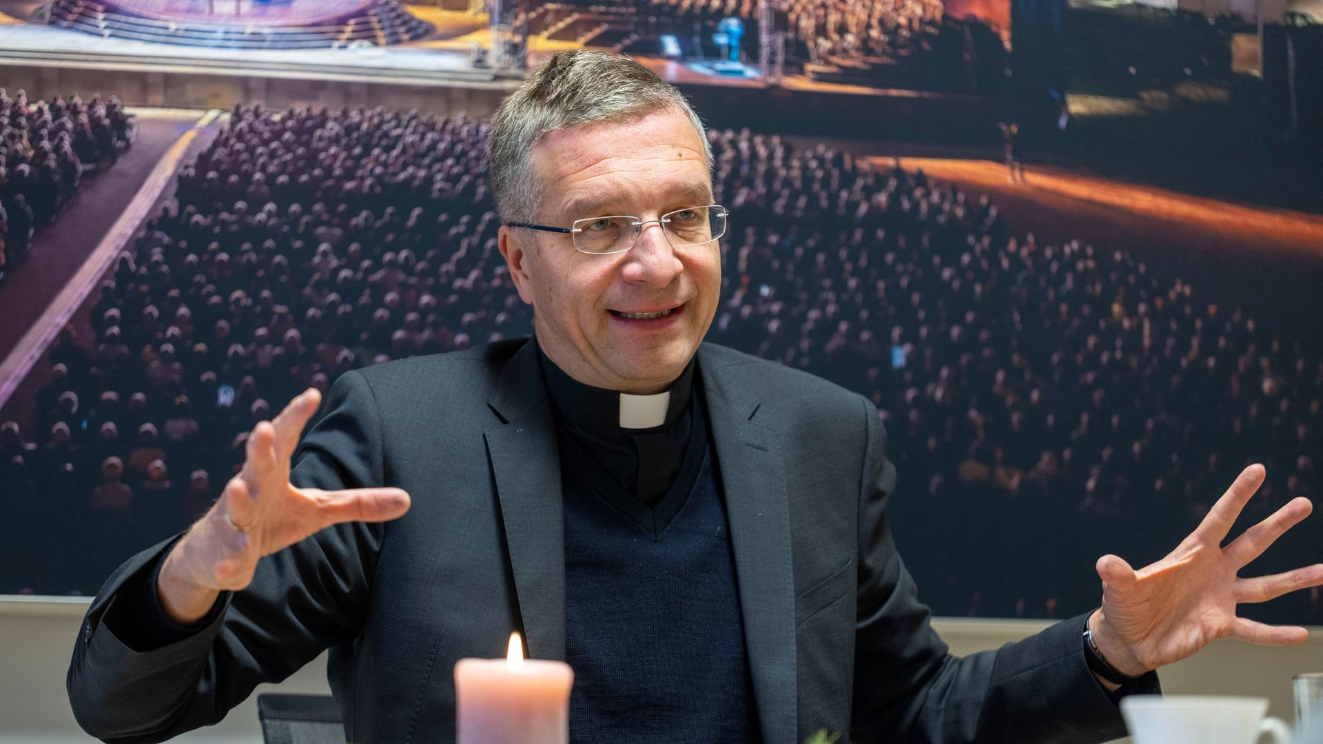 Der Fuldaer Bischof Michael Gerber spricht bei einem interview. Seine Hände gestikulieren. 
