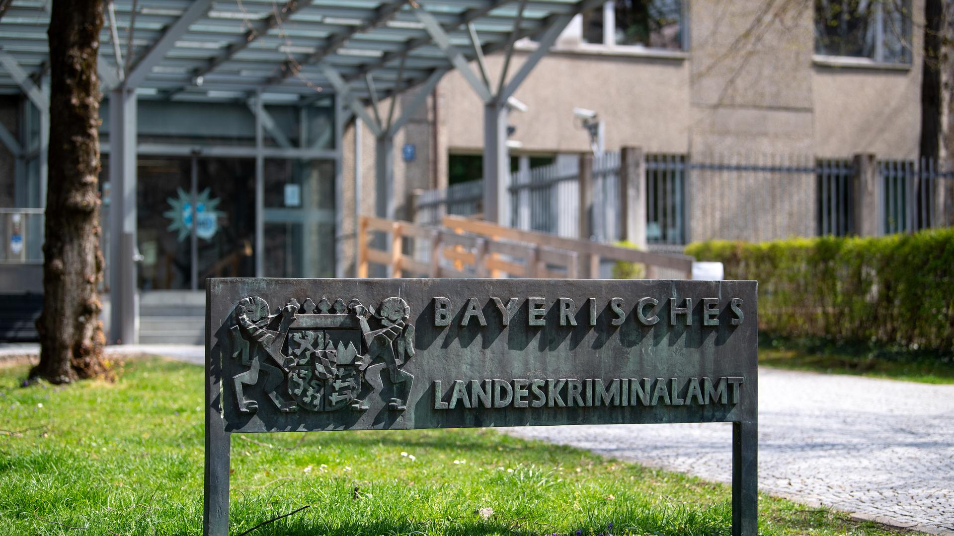 Ein Schild mit der Aufschrift "Bayerisches Landeskriminalamt" steht vor dem Eingang am Landeskriminalamt (LKA) in München. 