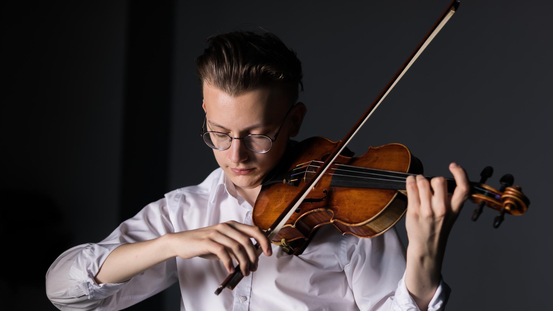 Portrait eines jungen Mannes, der auf einer Geige spielt