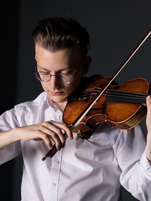 Portrait eines jungen Mannes, der auf einer Geige spielt