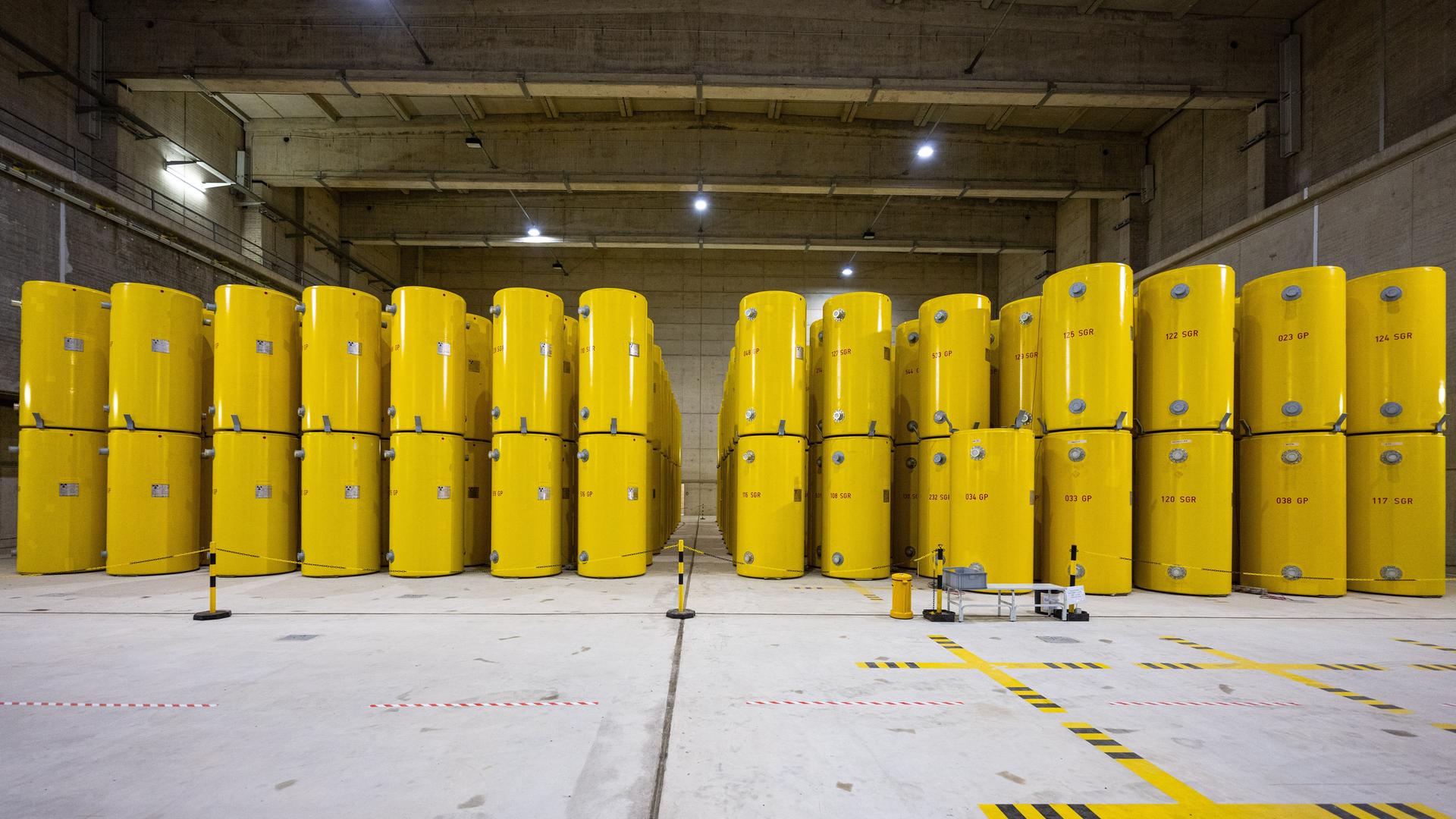 In einer Lagerhalle stehen hochradioaktive gelbe Castor-Behälter, die aus Atomkraftwerken in Ahaus zwischengelagert werden. Seit 1992 werden hier ausgediente Brennelemente aus Atomkraftwerken und Forschungsreaktoren aufbewahrt. 