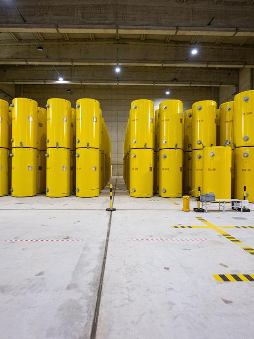 In einer Lagerhalle stehen hochradioaktive gelbe Castor-Behälter, die aus Atomkraftwerken in Ahaus zwischengelagert werden. Seit 1992 werden hier ausgediente Brennelemente aus Atomkraftwerken und Forschungsreaktoren aufbewahrt. 