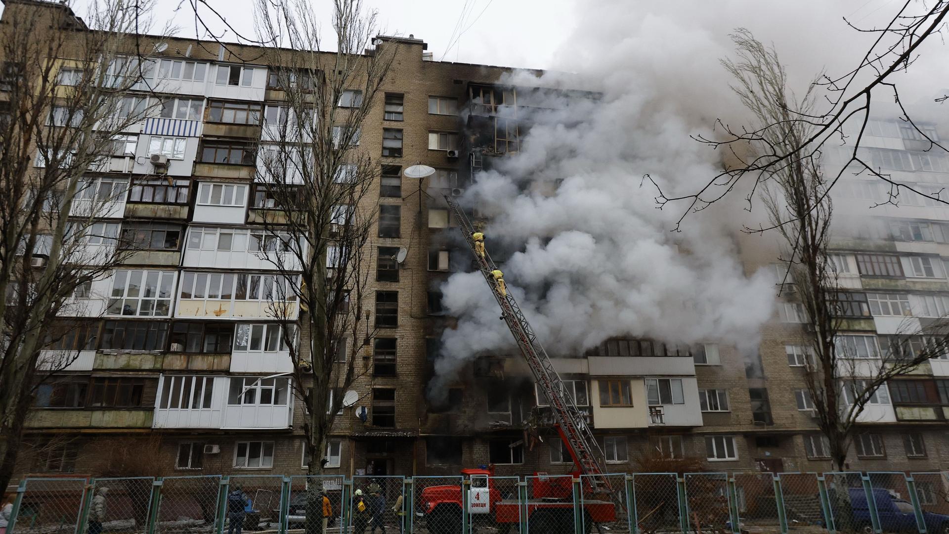 Ukraine, Donezk: Rauch steigt nach russischem Beschuss aus einem beschädigten Gebäude.