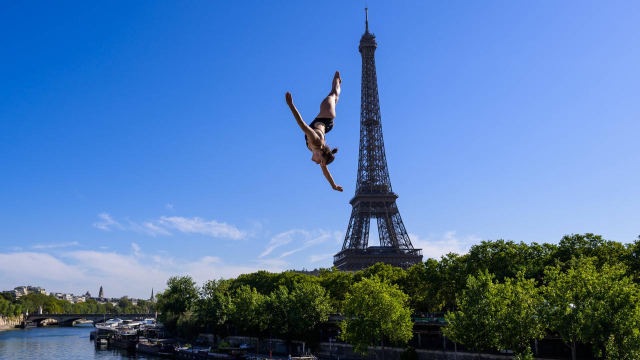Maike Elena Halbisch beim Sprung von der 20-Meter-Plattform in Paris am 7.8.2026; sie fliegt durch die Luft - unter ihr ist die Seine und hinter ihr der Eiffelturm zu sehen.
      