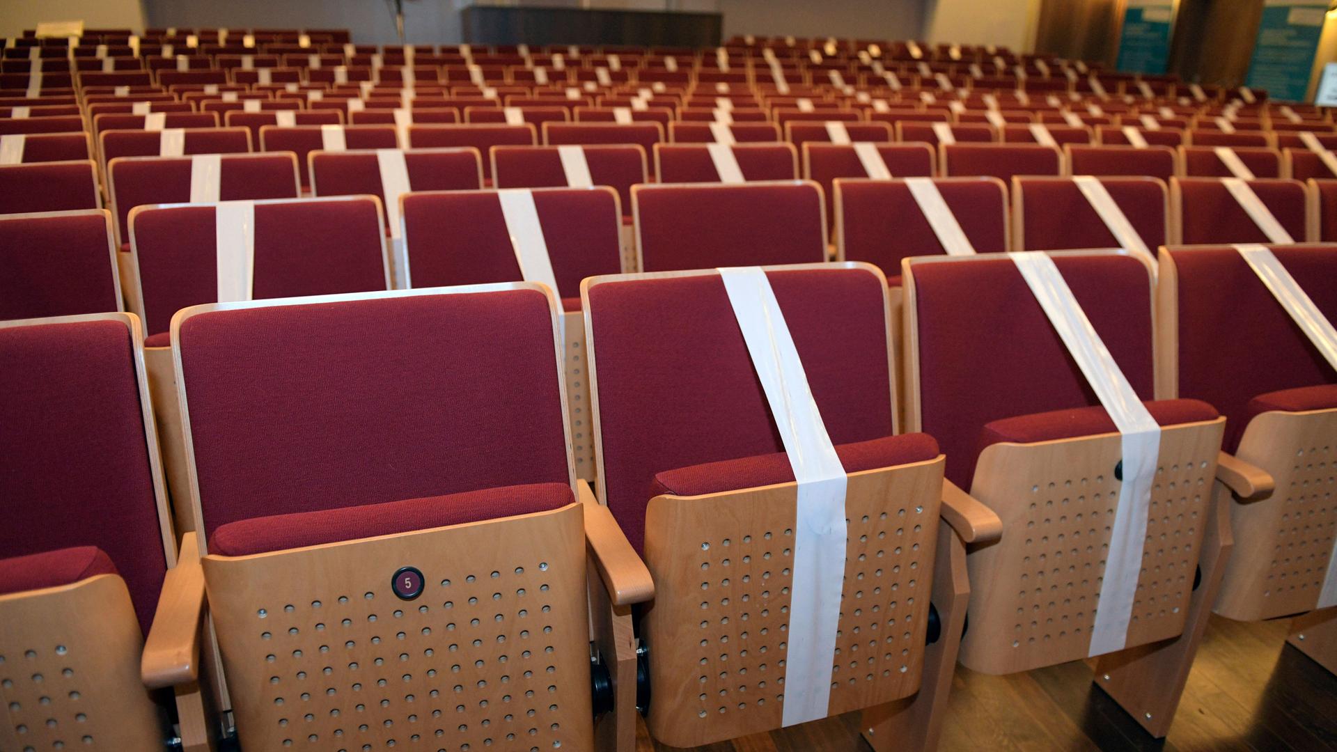 Rote Klappsessel, mit Sperrband abgeklebt. Drohen wieder Schließungen von Kultureinrichtungen Rote Klappsessel, mit Sperrband abgeklebt. Drohen wieder Schließungen von Kultureinrichtungen