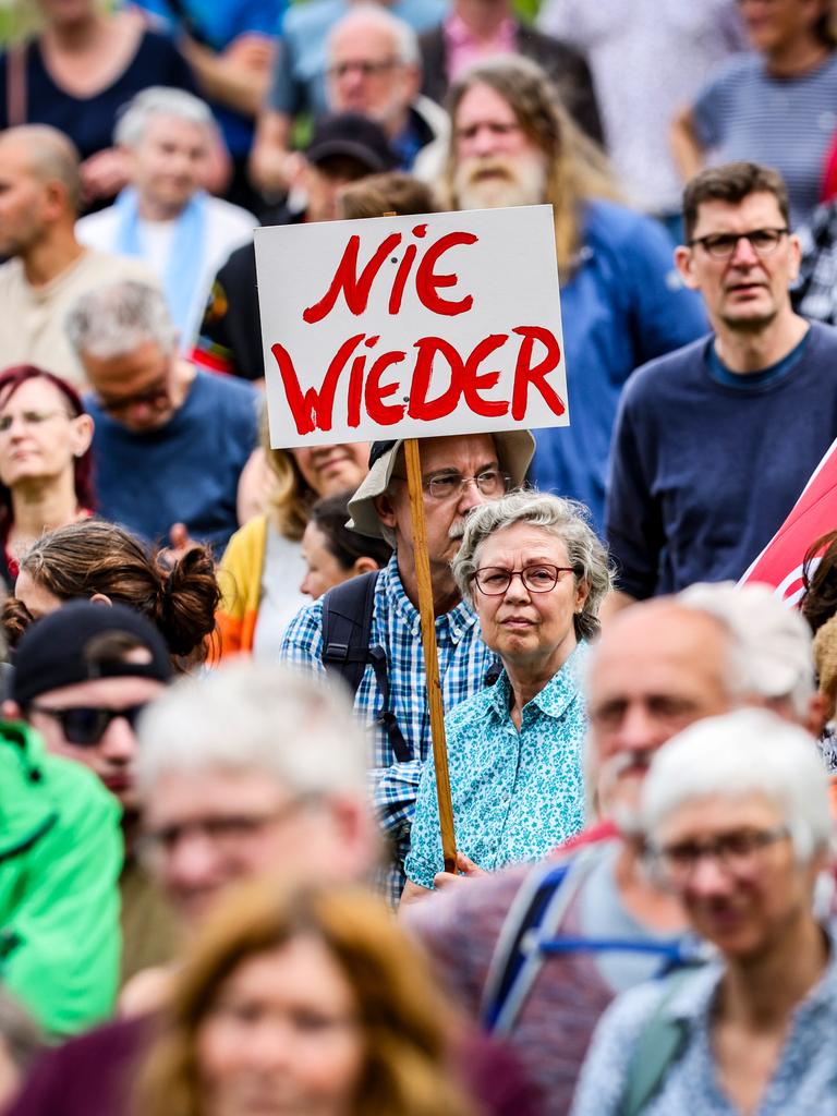 Demonstration gegen Rechts: Eine Frau hält ein Plakat hoch, auf dem "Nie wieder" steht.