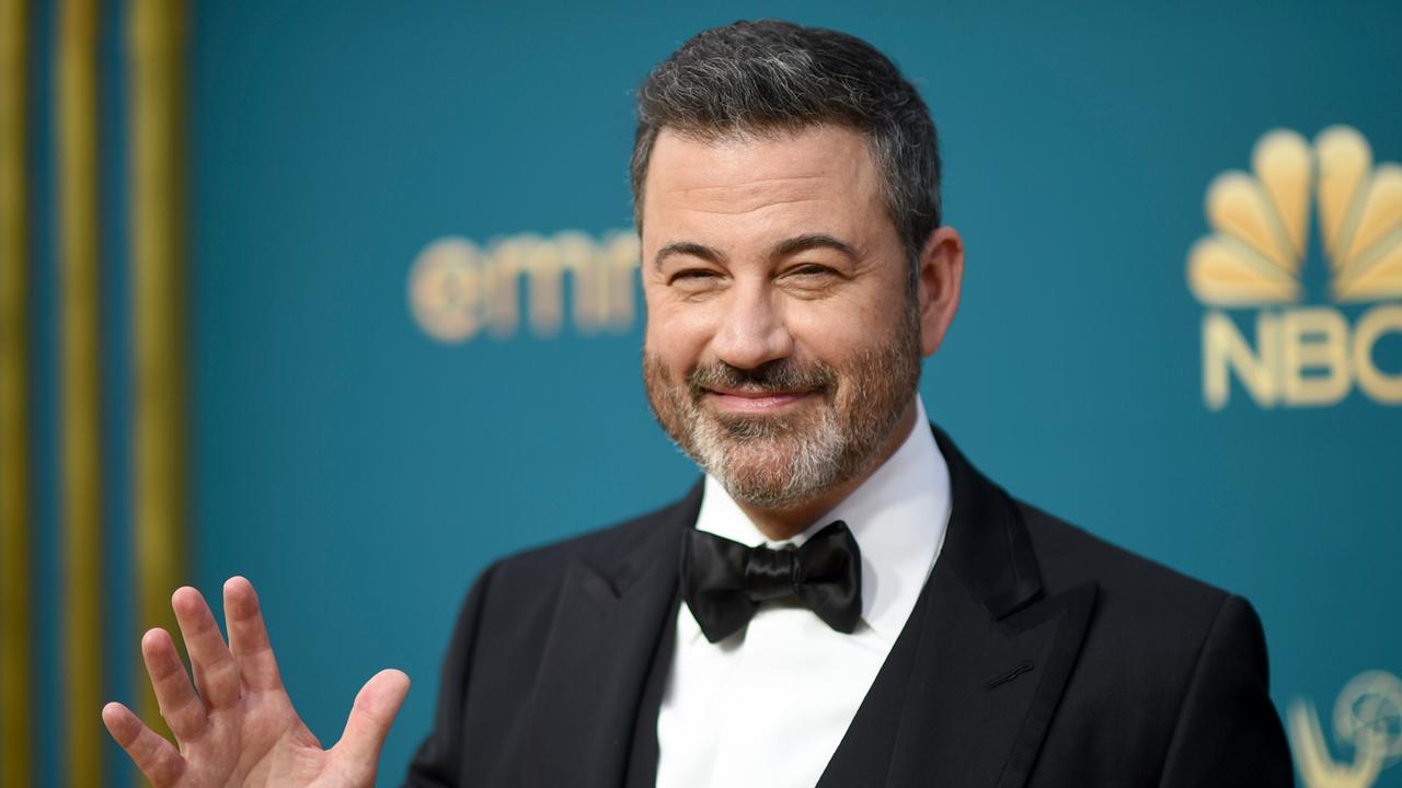 Late-Show-Moderator Jimmy Kimmel, ein Mann im mittleren Alter mit kurzen braunen Haaren im eleganten Anzug, winkt vor einer Wand, auf der Emmy Awards und NBC zu lesen ist. 12.09.2022