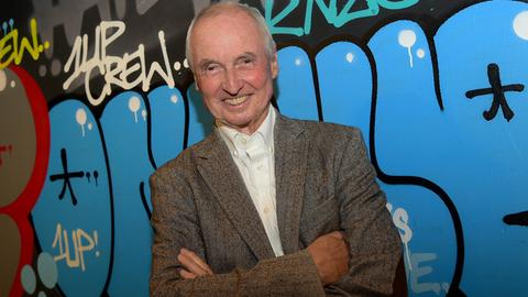 Ein Porträts des Autors und Journalisten Peter Pragal, ersteht vor einer mit Graffiti besprühten Wand im Berliner SO36