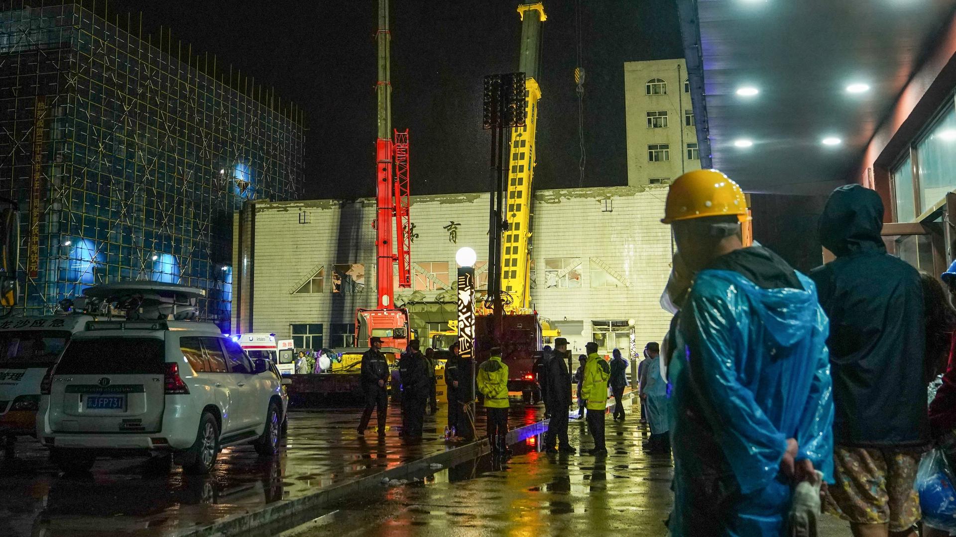 Hilfskräfte arbeiten mit Kränen an der Turnhalle, deren Dach eingestürzt ist. Hilfskräfte arbeiten mit Kränen an der Turnhalle, deren Dach eingestürzt ist.