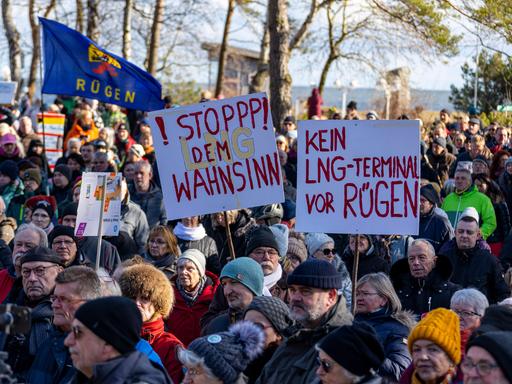 Demonstrierende auf Rügen halten Schilder hoch, auf denen steht "Kein LNG-Terminal vor Rügen" und "Stopp den LNG-Wahnsinn".