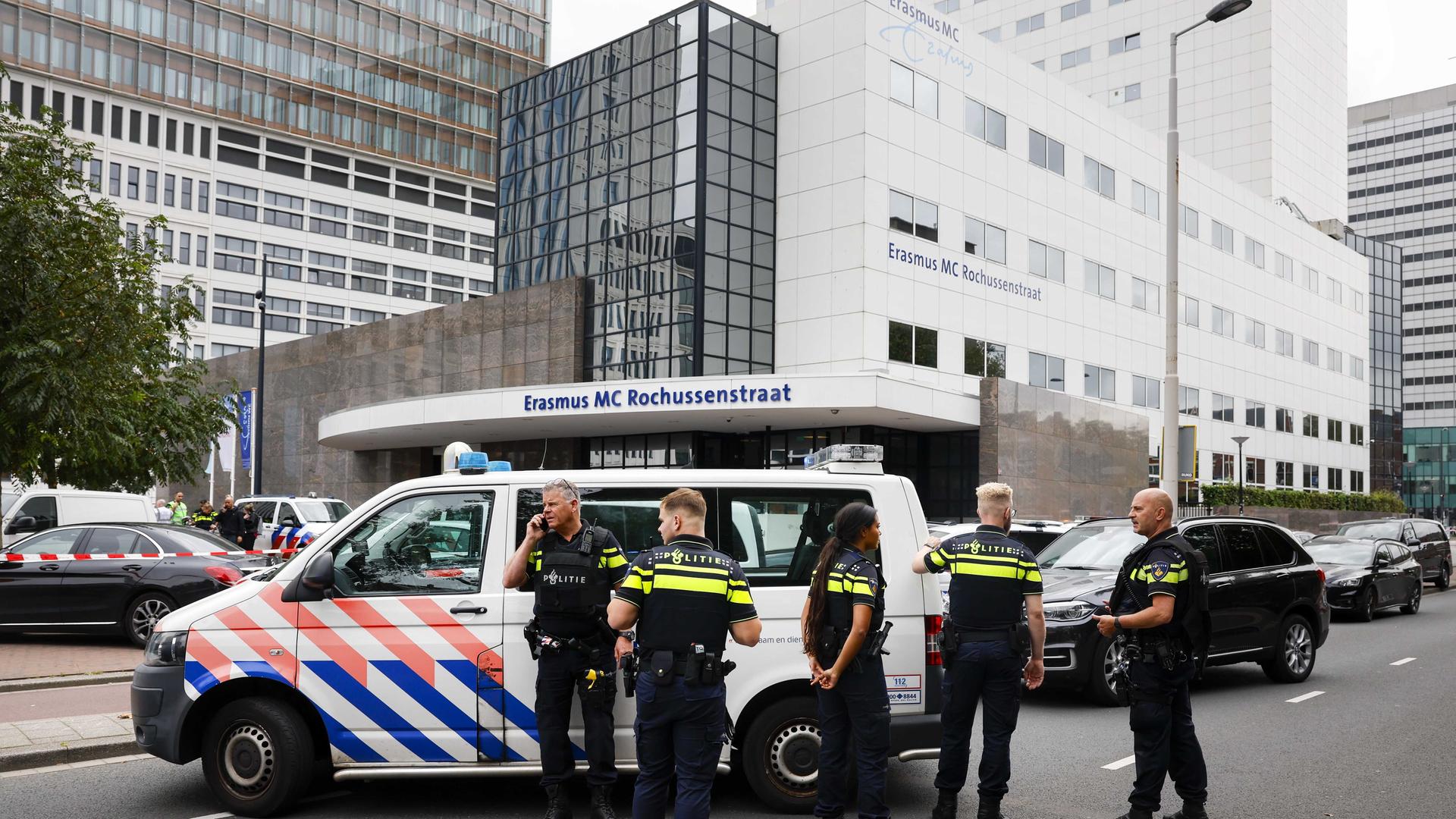 Polizeibeamte und ein Einsatzfahrzeug stehen vor einem Krankenhaus. Polizeibeamte und ein Einsatzfahrzeug stehen vor einem Krankenhaus.