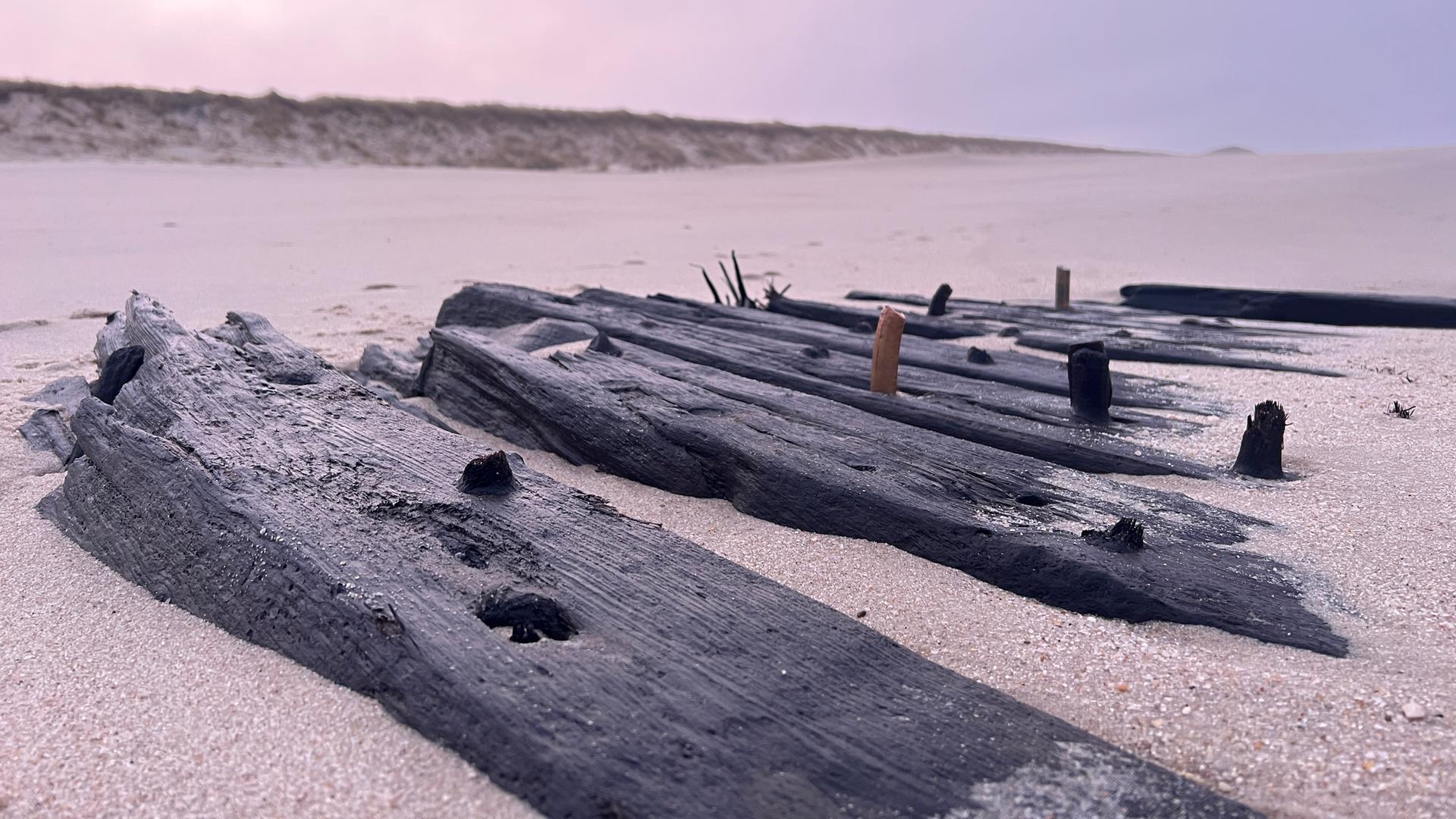 Verwitterte Überreste eines Schiffes liegen bei Ebbe am Strand von Sylt