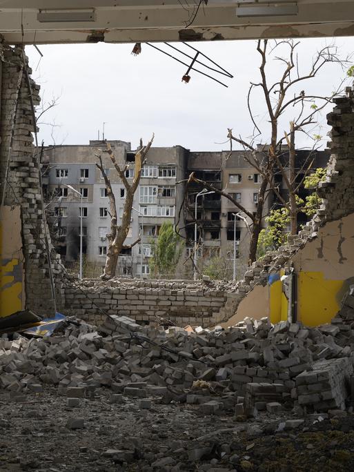 Der Blick aus einer zerstörten Wohnung in einem Haus auf die Hafenstadt Mariupol. 