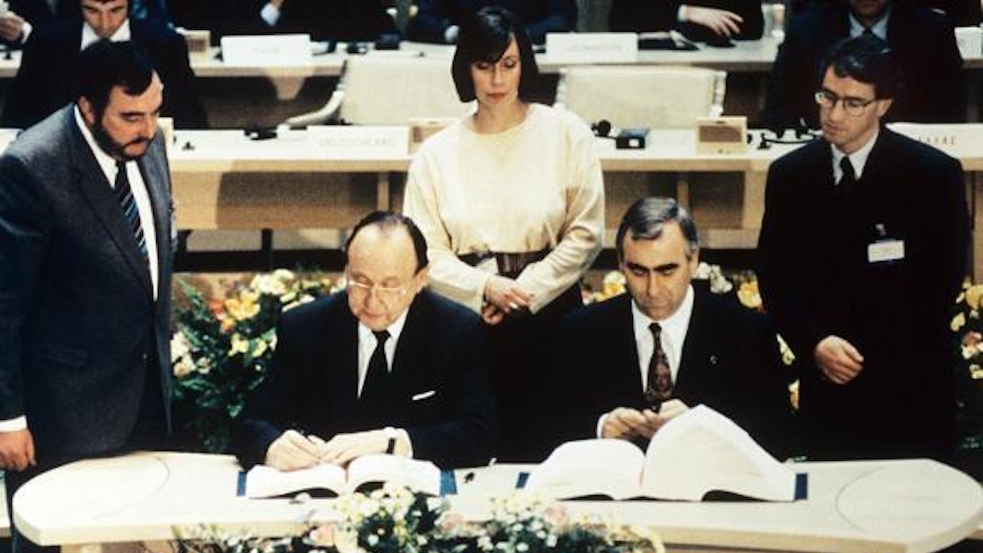 Bundesaußenminister Hans-Dietrich Genscher (l.) und Bundesfinanzminster Theo Waigel (r.) unterzeichnen am 7. Februar 1992 den Vertrag zur Wirtschafts- und Währungsunion der Europäischen Gemeinschaft in Maastricht (Niederlande).