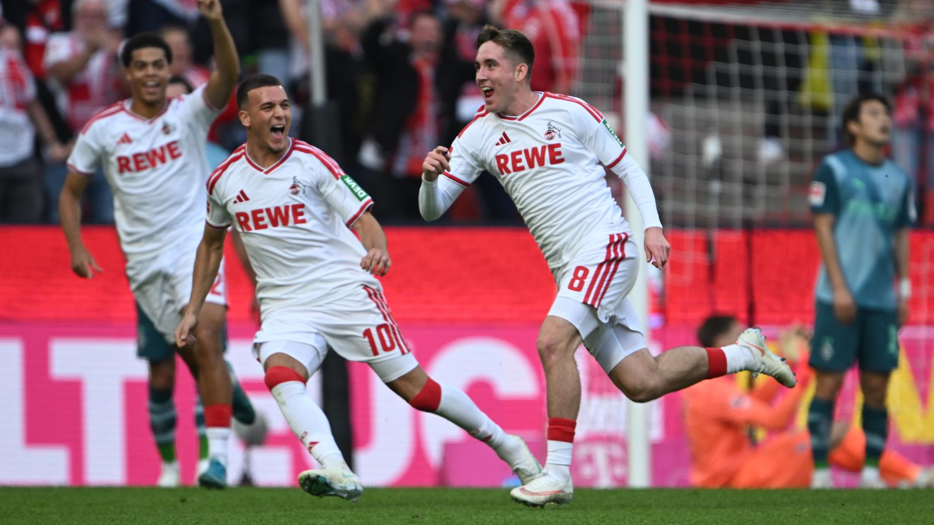 Die Fußballer Ísak Jóhannesson, Saïd El Mala und Jahmai Simpson-Pusey bejubeln ein Tor für Köln.