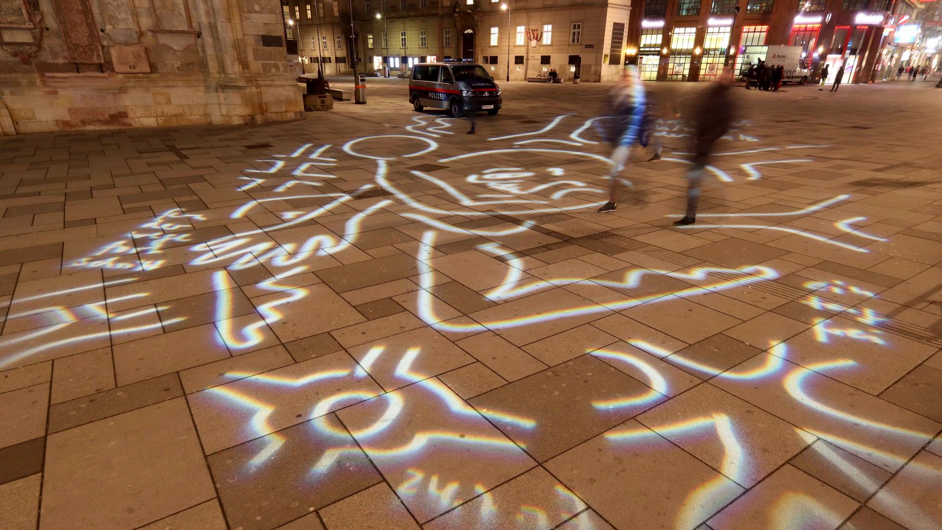 Eine LIchtgrafik der Künstlerin Gabriele Stötzer bedeckt mit Linien und Kringeln den Boden eines Platzes. Eine LIchtgrafik der Künstlerin Gabriele Stötzer bedeckt mit Linien und Kringeln den Boden eines Platzes.