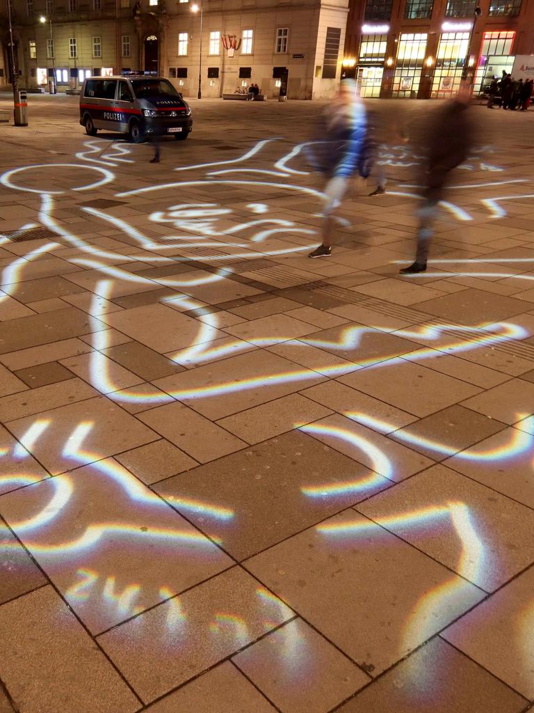 Eine LIchtgrafik der Künstlerin Gabriele Stötzer bedeckt mit Linien und Kringeln den Boden eines Platzes. 