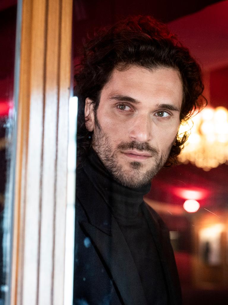 Sänger Vladimir Korneev schaut aus einem Fenster in der Bar jeder Vernunft in Berlin, im Hintergrund sieht man verschwommen einen Kronleuchter.